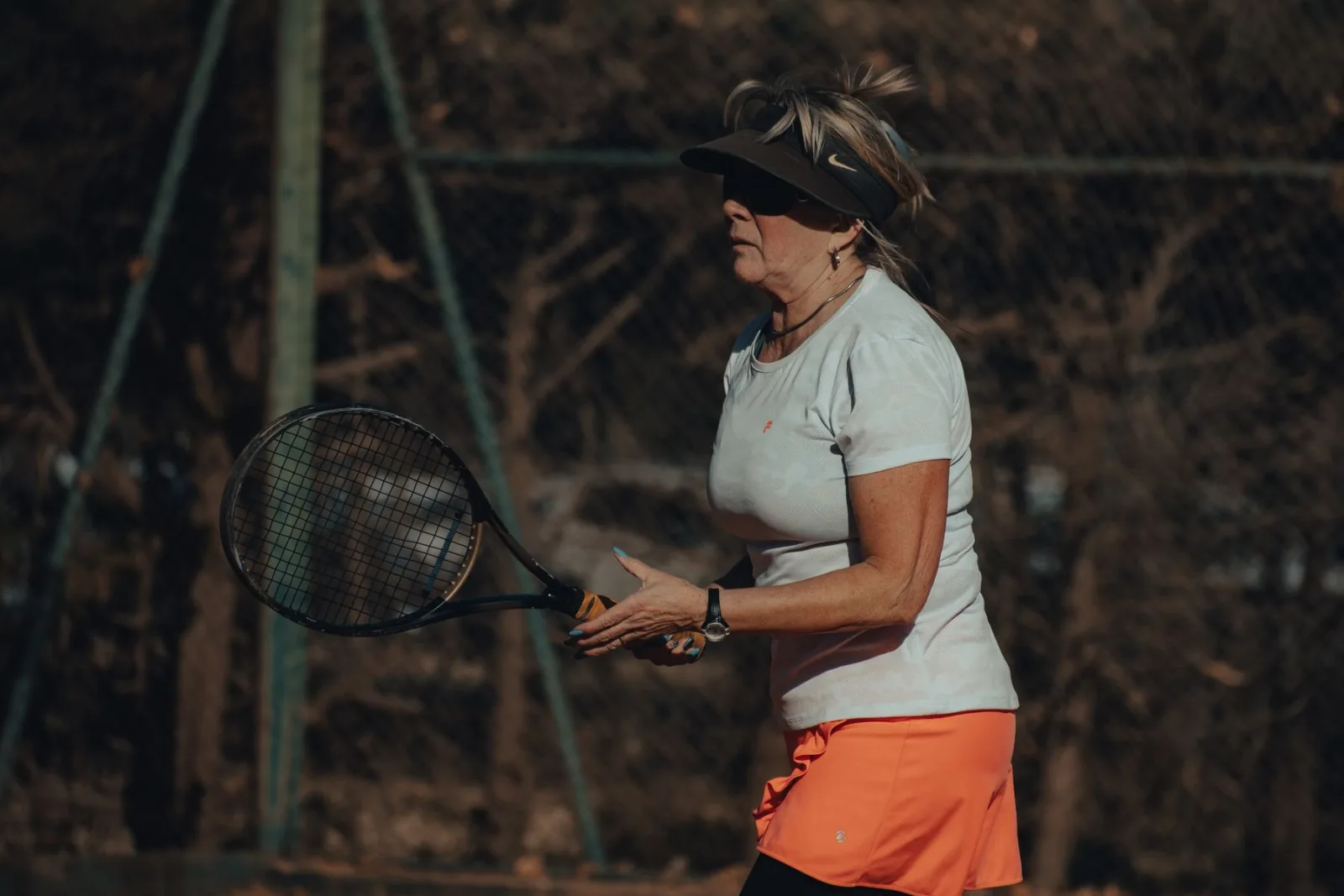 A woman over 50 focused on the next point during a tennis match